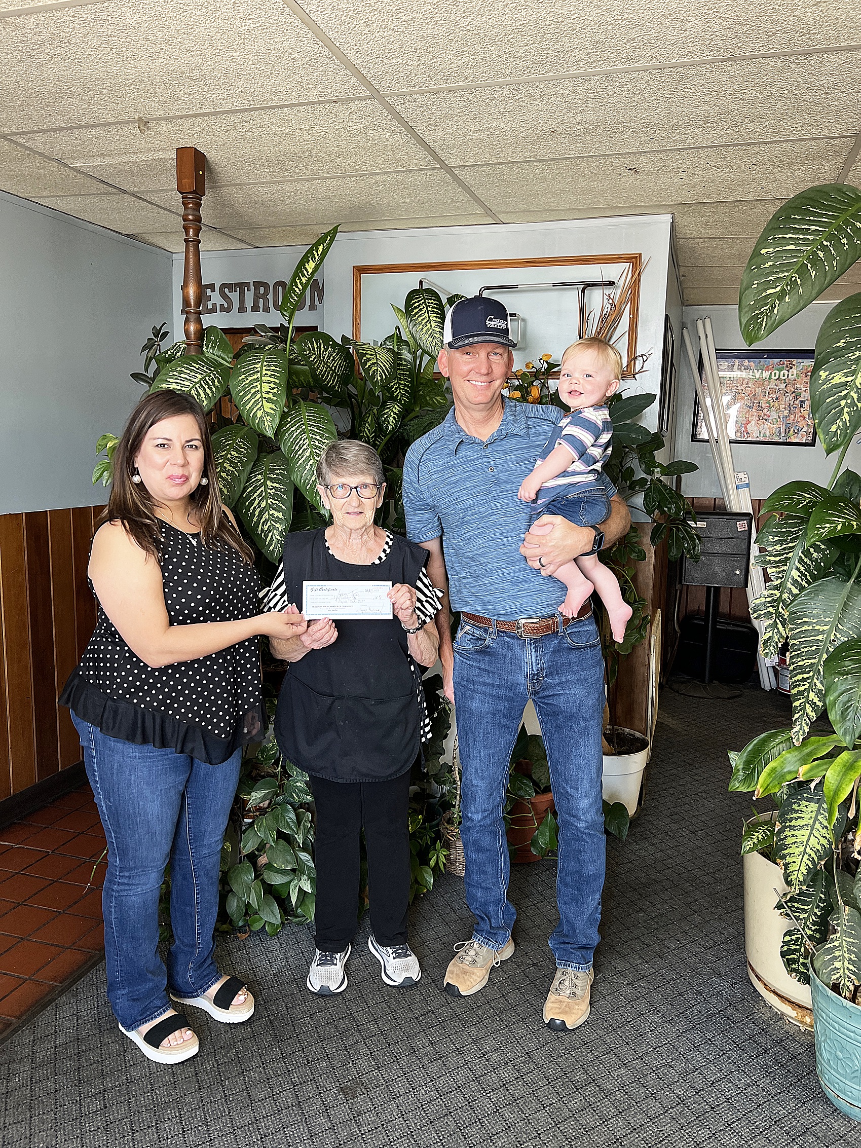 Super Dad Jason Teeter is presented his Gift Certificate from Chamber Director Tina 
Fernandez, left, and two free dinners from Lana Slocum and the Jet Drive-in, center.  Jason and his wife Jacque have three sons, Jacob, Jaxon and Jadon and happy little grandson Wesley Hayes Teeter pictured here with his proud grandfather.