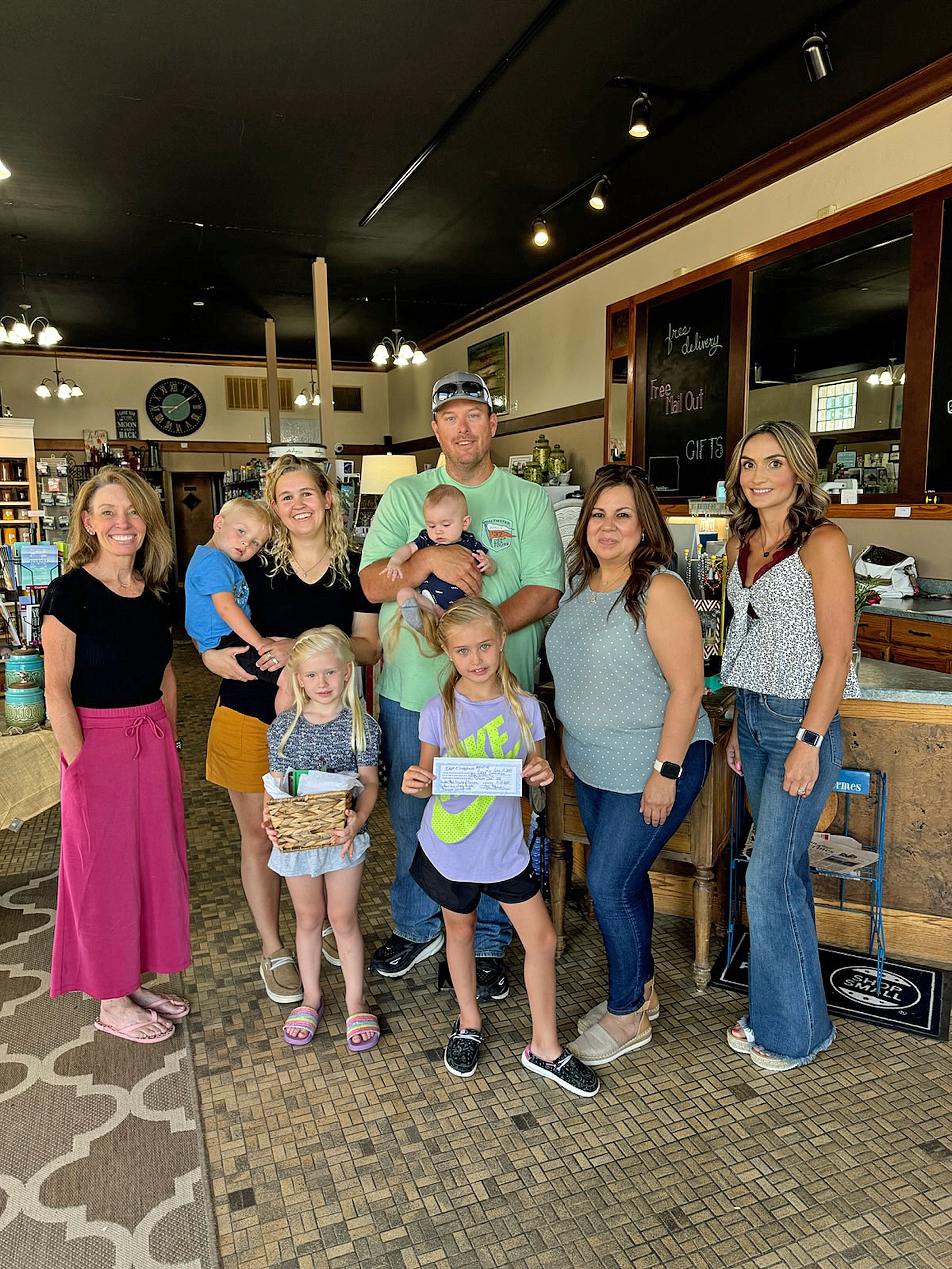 Super Dad Casey Settlemyer is pictured with his family as Leigh Angell to the left and Tasha Medina to the right, present him with his specially filled gift basket from Hugoton Drug. From left to right is the 
Settlemyer family - Cody with Beth, Rylee and Sadie, and Casey with Rigley. Tina 
Fernandez, the director of Hugoton 
Chamber is next to Casey. She presented Casey with the $50 Gift Certificate. 
The girls were the ones who signed their Super Dad up at all the businesses. 
Congratulations Casey!!